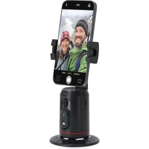A black and red automatic tracking phone holder with a smartphone securely attached, capturing a selfie of two people.