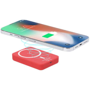 A red power bank with a wireless charging design, positioned near a smartphone showing a charging icon.