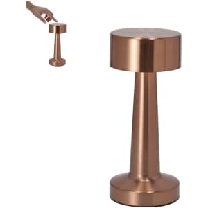 A copper lamp with a cylindrical base and rounded top, featuring a hand reaching towards it.