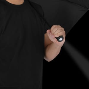 A black umbrella held by a person, featuring a handle with a flashlight function.