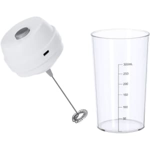 A mixing cup with a clear design and measurement markings, accompanied by a white electric frother with a logo.