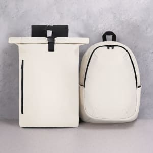 A white Kalek backpack and a white roll-top backpack with black accents and a logo.