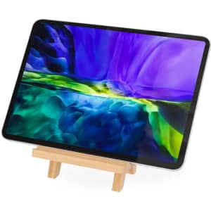 A wooden phone stand displaying a tablet with a vibrant purple and green abstract background.