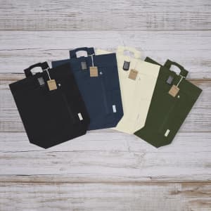 A collection of Antrim Backpacks in black, navy, cream, and green, featuring a front pocket and a handle.
