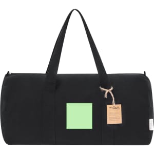 A black tote bag with a green square patch and a tag, featuring sturdy handles for easy carrying.