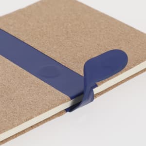 A brown notepad with a blue elastic band holding it closed. The notepad has a simple, minimal design.