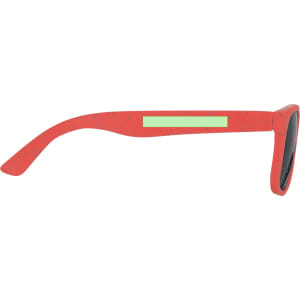 A pair of red kids' sunglasses with a smooth frame and dark lenses, featuring a branding logo on the side.