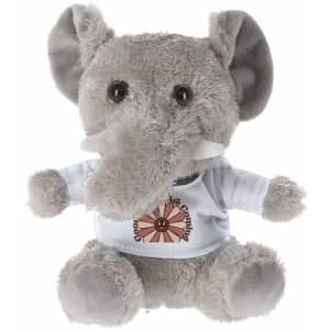 A grey plush elephant toy with large ears, wearing a white shirt featuring a graphic design, and has a logo.