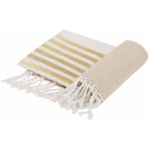 A striped bath towel in white and gold, featuring a fringed edge and rolled up with a plain section exposed.