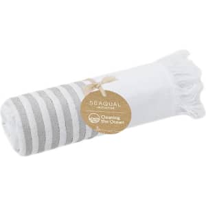 A rolled white and grey striped towel with fringe, tagged with a logo for a cleaning initiative.