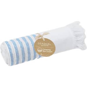 A rolled towel featuring white and blue stripes, with a tag indicating a sustainability initiative.