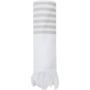 A rolled white towel with grey stripes and fringed edges, featuring a logo.