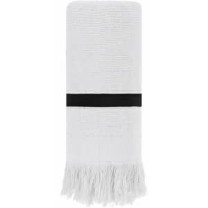 A rolled white towel with fringe detailing and a black band around it, featuring a logo.