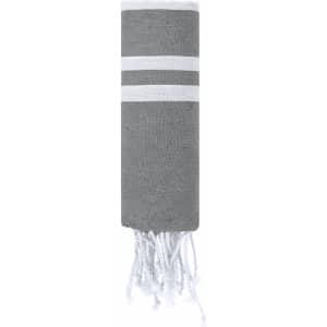 A grey towel pareo with white stripes and fringed ends, featuring a brand logo. Ideal for leisure and outdoor activities.