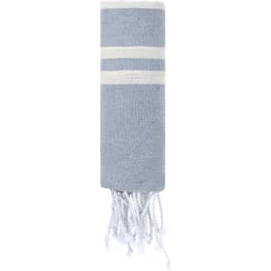 A blue towel pareo with white stripes and fringed edges. The product includes a branding logo.