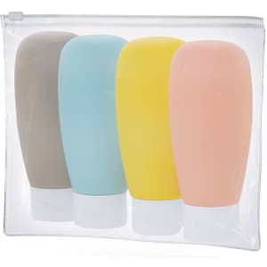 A clear toiletry bag contains four travel-size bottles in grey, blue, yellow, and pink. The bag has a zip closure.