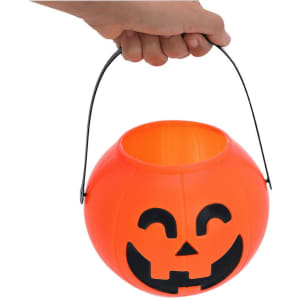 An orange pumpkin-shaped Halloween basket with a smiling face and a black handle for carrying.