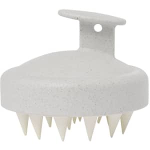 A scalp massager in a speckled light grey colour with white plastic bristles and a convenient handle for grip.