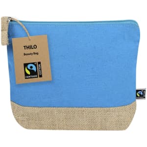 A blue toiletry bag with a natural jute base and a tag indicates it is a Thilo Fairtrade Beauty Bag.