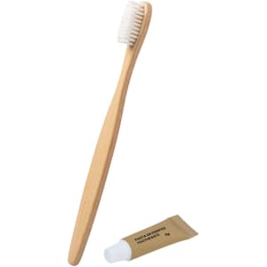 A bamboo toothbrush with soft bristles and a small tube of toothpaste. Both items are eco-friendly and natural in colour.