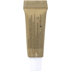 A small beige tube with a white cap, containing a cream or ointment, featuring a logo and various ingredient details.