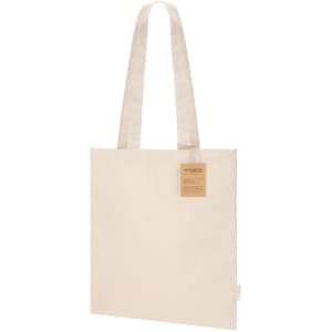 A beige tote bag with long handles and a tag, featuring a simple design and a logo.