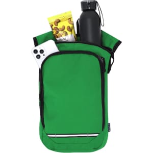 A green backpack with a drink bottle, snacks, and a smartphone partially visible inside. The backpack has a logo.