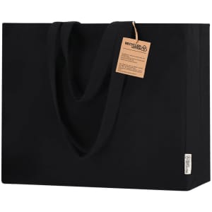 A black tote bag with sturdy handles and a tag attached, featuring a logo and made from recycled materials.