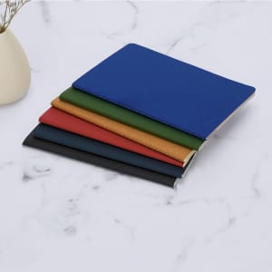 A set of Qeton Notebooks in blue, green, red, orange, and black, arranged on a marble surface.