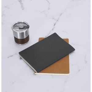 A black notebook and a brown notebook are placed on a marble surface beside a silver and wooden drink bottle.