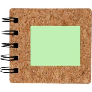 A cork notepad with a green sticky note area and a spiral binding. Features a logo on the front cover.