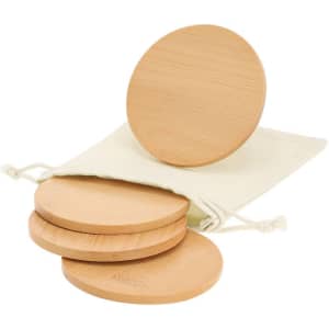 A set of four round bamboo coasters stacked with a natural fabric storage pouch.