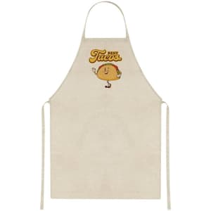 A beige apron featuring a cartoon taco character and a logo. It has tie straps for adjustment.