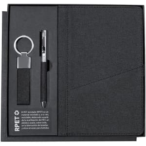 A black gift set featuring a notebook, pen, and keyring, all presented in an organised box with a logo.