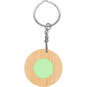 A bamboo keyring featuring a circular shape with a light green centre and a metal ring for attachment.