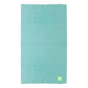 A turquoise beach towel with a textured surface and fringe edges, featuring a small logo.