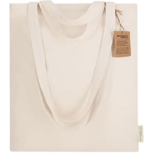 A tote bag in a cream colour with dual handles and a tag attached, featuring a simple design and no visible branding.
