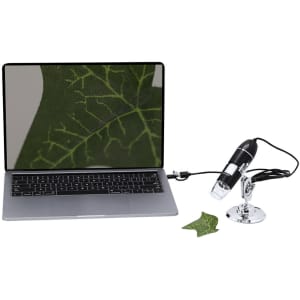 A black microscope with a chrome stand connected to a laptop, displaying a close-up of a leaf on the screen.