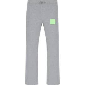 A pair of grey track pants featuring a small green patch and an elastic waistband. Includes a logo.