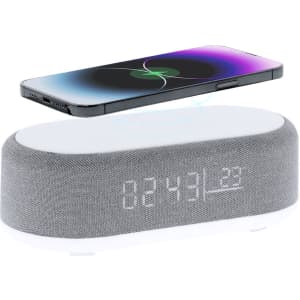 A grey multifunction alarm clock with a phone wirelessly charging on top and a digital display showing the time.
