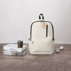 A neutral-coloured backpack with a black zipper sits beside books and a drink bottle on a wooden surface.