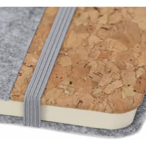 A grey felt notepad with a cork cover and an elastic band closure. It features a simple, understated design.