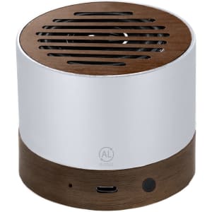A compact speaker featuring a silver metallic top and a wooden base, with ventilation slots on the top.
