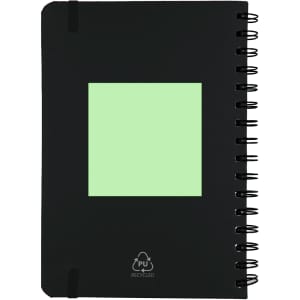 A black spiral-bound notebook with a green square and a logo. The cover is made from recycled materials.