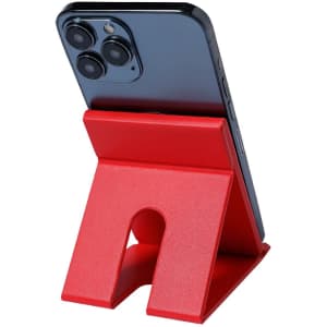 A red stand holds a smartphone with three rear cameras, designed for stability and convenience.