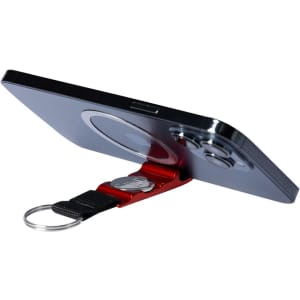 A red keyring holder with a coin, supporting a smartphone in a vertical position. Features a logo on the keyring.