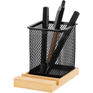 A black mesh pencil holder featuring several black pens, set on a bamboo base.