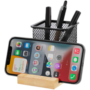 A black mesh pencil holder with several pens and a wooden stand holding a smartphone.