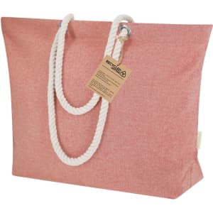 A pink tote bag with rope handles and a tag, featuring a textured fabric design.
