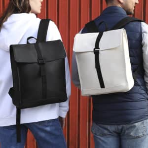 A black and a white Teylok Backpack are being worn by two people from the back, against a red backdrop.